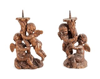 A Pair of Continental Carved Wood Cherubic Prickets