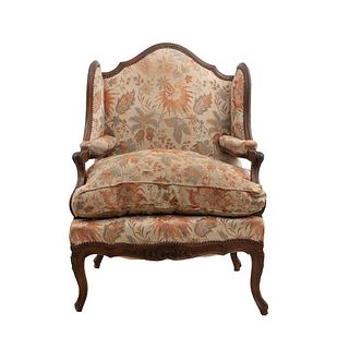 Sillón. Francia. Siglo XX. Estilo Luis XV. En talla de madera de roble. Con respaldo cerrado y asiento con cojín en tapicería floral.