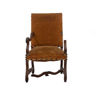 Sillón. Francia. Siglo XX. Estilo Enrique II. En talla de madera de roble. Con respaldo cerrado y asiento en tapicería color mostaza.