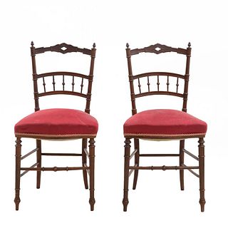 Par de sillas. Francia. Siglo XX. En talla de madera de nogal. Con fustes escalonados, asientos en tapicería color rojo.