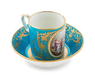 A Sevres Style Painted, Parcel Gilt and "Jeweled" Turquoise-Ground Porcelain Cup and Saucer