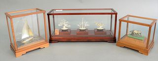 Three Japanese silver pieces in glass cases to include triple tree, ht. 5 1/4", wd. 14 1/4"; sailboat, ht. 7 3/4", wd. 7" and a steer, ht. 5 3/4", wd.