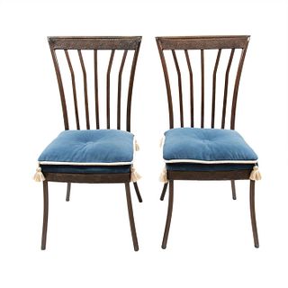 Par de sillas. Siglo XX. Elaboradas en metal. Con respaldos semiabiertos, asientos con cojines capitonados color azul.