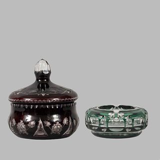 Bombonera y cenicero. Origen europeo. Siglo XX. Elaborados en cristal tipo Bohemia en colores granate y verde.