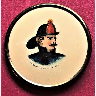 A FRAMED AMERICAN BUTTON DEPICTING A FIREMAN ON IT.