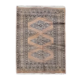 Tapete. Pakistán. Siglo XX. Estilo Boukhara. Elaborado en fibras de lana y algodón. Decorado con elementos geométricos. 123 x 73 cm.