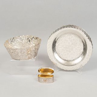 Lote de 3 piezas. Siglo XX. Elaboradas en plata y metal plateado. Consta de: corona, plato decorativo y pastillero.. Peso: 957 g.