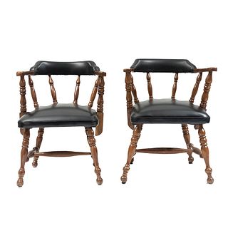 Par de sillones. Siglo XX. En talla de madera. Con respaldos semicurvos y asientos de vinipiel color negro.
