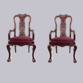 Par de sillones. Siglo XX. Estilo Chippendale. En talla de madera. Con respaldos semiabiertos y asientos en tapicería roja.