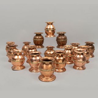 Lote de 17 floreros. Siglo XX. Diseño a manera de jarrón. Elaborados en cobre martillado. Con pesos de plomo en las bases.