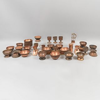 Lote de 40 piezas. Siglo XX. Elaborados en cobre. Consta de: depósitos, copas, charola, taza. Decorados con elementos orgánicos.