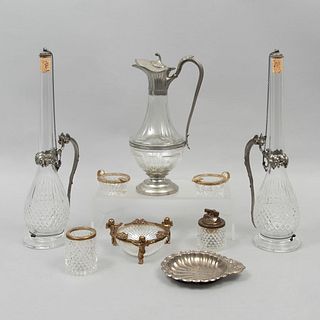 Lote de 9 piezas. Siglo XX. Elaboradas en cristal y metal. Consta de: jarra, encendedor, vaso, 2 licoreras y 4 ceniceros.