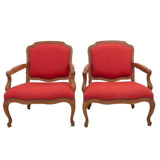 Pair of armchairs. 20th century. Carved in wood. With closed backrests and seats in red upholstery, semi-curved shafts.