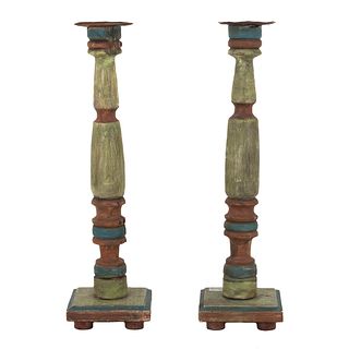 Pair of candelholders. 20th century. Polychrome wood, circular washers, compound shafts, quadrangular bases.