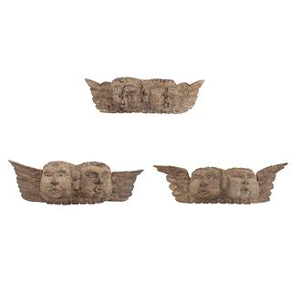Lot of 3 double-headed cherubs. 20th century. Carved in wood. 10.6 x 35.8 x 6.2" (27 x 91 x 16 cm)