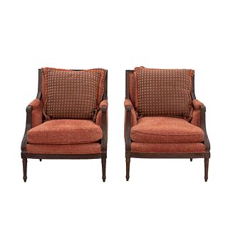 Pair of armchairs. 20th century. Carved in wood. Closed backrests and seats with cushions in orange upholstery.