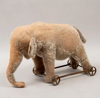 Elefante de juguete. Alemania. Siglo XX. Marca Steiff. Elaborado en peluche. Soportes con ruedas de metal.