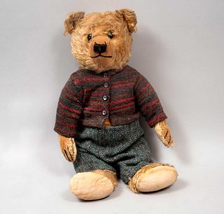 Oso de juguete. Alemania. Siglo XX. Marca Steiff. Elaborado en peluche. Vestido con suéter y pantalones.