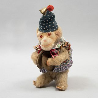 Mono de juguete. Siglo XX. Elaborado en peluche. Toca los platillos. Vestido con gorro y blusa con olanes. 21 cm
