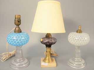 Three glass oil lamps to include blue opalescent glass oil lamp on clear base, white opalescent oil lamp and amethyst oil lamp, hts. 10", 21" and 15".