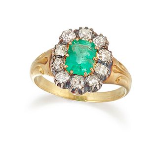 AN EMERALD AND DIAMOND CLUSTER RING, the octagonal step cut emerald, claw m