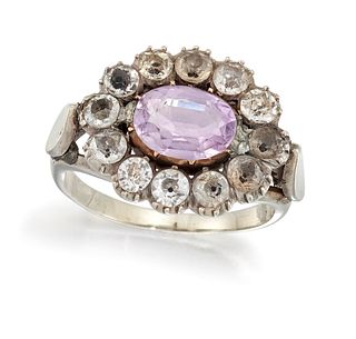 AN AMETHYST AND PASTE RING, the oval amethyst in rubover mount, surrounded 