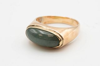 A 14CT YELLOW GOLD AND GREEN STONE RING, the oval cabochon green stone set 