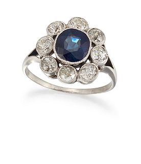 A SAPPHIRE AND DIAMOND CLUSTER RING, the off-round sapphire, estimated appr