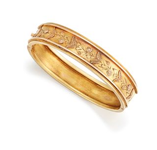 A LATE 19TH CENTURY HINGED BANGLE, the upper half with raised and bright cu