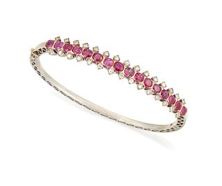 A RUBY AND DIAMOND HINGED BANGLE, the sixteen oval rubies, total estimated 