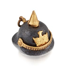 A MINIATURE PICKELHAUBE CHARM, in gilt and bronze metal, with small hanging