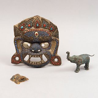 Lote de 3 piezas. SXX. Estilo tibetano. En metal. Consta de: máscara, elefante y sapo. Decorados con incrustaciones de coral y turquesa