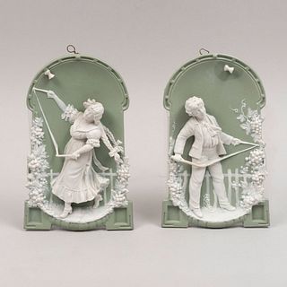 Par de niños. Inglaterra. Siglo XX. Elaborados en porcelana Wedgwood. Con fondo verde.