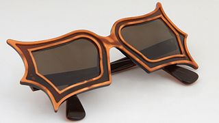 Pair of Limited Edition Safilo Sunglasses, inspired by Peggy Guggenheim, with butterfly shaped orange lucite frames, the right inter...