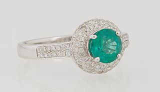 Lady's 14K White Gold Dinner Ring, with a circular .78 carat emerald atop a triple rounded concentric graduated border of round diam...