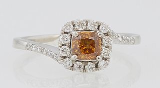 Lady's Platinum Dinner Ring, with a .61 cushion cut brownish orange yellow diamond, atop a conforming border of round diamonds on a...