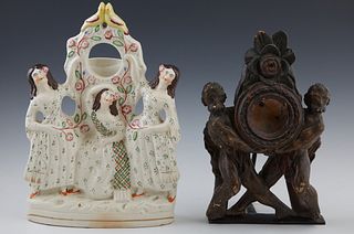 Two Pocket Watch Holders, 19th c., one a Staffordshire figural example; the second of carved wood with figural supports, on a cast i...