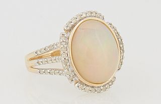 Lady's 14K Yellow Gold Dinner Ring, with a 4.64 carat oval cabochon opal atop a pierced border of small round diamonds, on triple sp...
