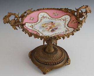 Sevres Porcelain Compote, 19th c., the rim with gilt bronze leaf and grape mounts and a leaf and floral handle, around a floral border surrounding a r