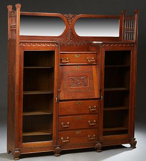 American Carved Oak Side-by-Side Secretary Bookcase, c. 1890, the double wide beveled mirror back flanked by spindled galleries, over a center drawer 