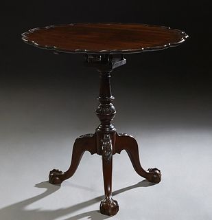 English Style Carved Mahogany Tilt Top Table, 20th c., the scalloped piecrust top on a birdcage support on a turned tapered column to tripodal cabriol