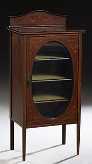 English Marquetry Inlaid Carved Mahogany Music Cabinet, c. 1910, the stepped arched back splash, over a parquetry inlaid oval glazed door, enclosing f