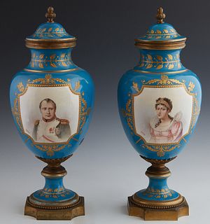 Pair of Sevres Style Porcelain Covered Baluster Urns, 19th c., of tapering form, with bronze mounted lids and rims, on bronze socle supports to shaped