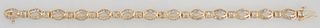 14K Yellow Gold Link Bracelet, each of the 13 oval pierced diamond mounted links joined by an arched link with two round diamonds, total diamond wt.- 