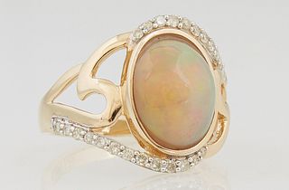 Lady's 14K Yellow Gold Dinner Ring, with an oval cabochon 2.74 ct. opal, on a pierced bypass band mounted with edge diamonds, total diamond wt.- .27 c