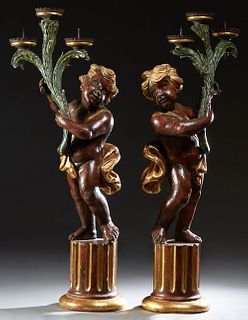 Unusual Pair of Large Patinated and Gilt Composite Putti Candelabra, 20th c., each standing on a reeded column base, upholding a three prong branch to
