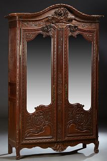 French Provincial Louis XV Style Carved Oak Marriage Armoire, 19th c., the arched crown over a central high relief bird, quiver, torch and flower carv