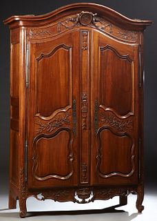 French Louis XV Style Carved Walnut Armoire, c. 1800, the stepped arched crown over a central medallion flanked by garlands, over double two fielded p