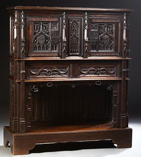 Exceptional French Carved Oak Gothic Sideboard, 19th c., with a stepped rounded edge crown over setback double Gothic arch carved doors, with central 
