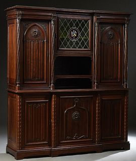 French Carved Walnut Gothic Style Breakfront Sideboard, late 19th c., the ogee breakfront crown over a setback leaded glass armorial center door above